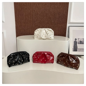 Detail view of ruched cloud bags with gold studs in white, black, burgundy, and brown