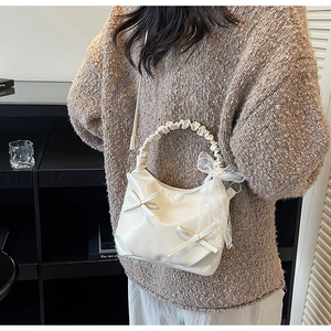 Detail of white PU cloud bag featuring decorative 3D bows and elegant lace ribbons