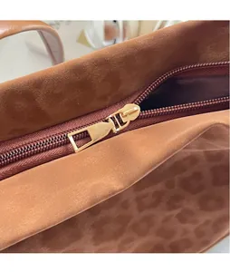 Detail of the high-quality gold zipper and soft brown suede leopard tote bag
