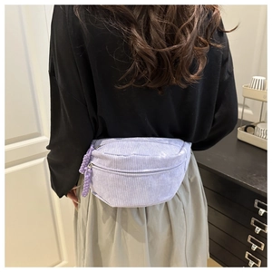 Close-up of lavender corduroy waist bag showing double zippers and soft texture detail