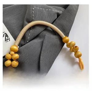 Detail der kunstvollen chinesischen Stickerei und des handgefertigten Holzperlengriffs
