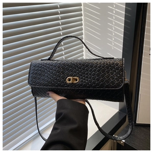 Détail du sac carré en cuir tressé noir avec un fermoir rotatif en métal doré élégant