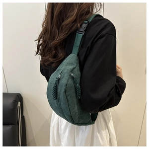 Detail of dark green corduroy waist bag with textured vertical stripes and buckle strap