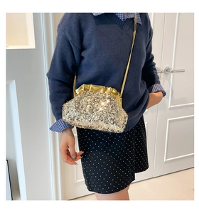 Close-up of sparkling gold sequin dumpling tote bag with a metallic pleated closure
