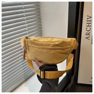 Detail of yellow corduroy fanny pack showing textured fabric and braided zipper pull