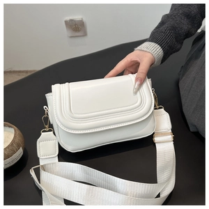 White faux leather saddle bag detail with wide fabric strap and golden metal hardware