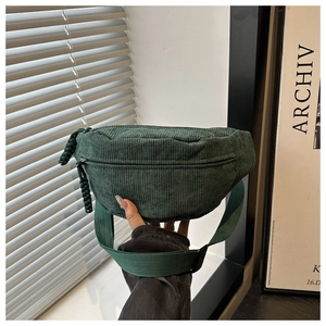 Detail of dark green corduroy waist bag showing soft texture and adjustable woven strap