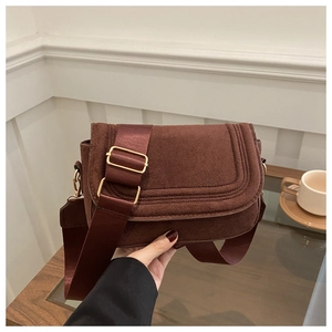 Detail of burgundy suede saddle bag with adjustable wide nylon shoulder strap