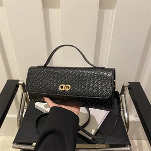 Sac à main carré noir tissé avec boucle dorée CD porté à la main élégamment