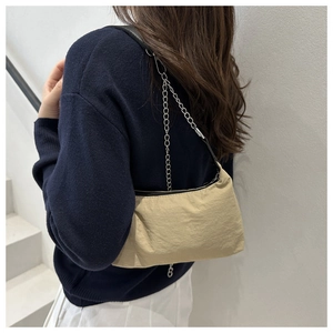 Détail du sac à bandoulière en nylon kaki avec chaîne argentée et fermeture éclair