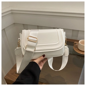 Detailed view of white saddle bag with parallel stitching and adjustable wide strap
