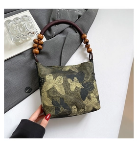 Nahaufnahme der Schmetterlingsstickerei und Holzperlen an der Damen-Handtasche