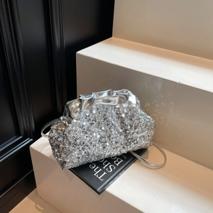 Silver sequin hobo bag with wavy pleated trim on a stylish display stand