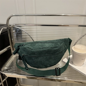 Minimalist dark green corduroy waist bag with adjustable strap in modern home setting