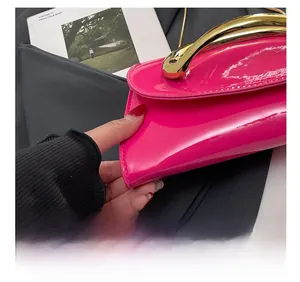 Close-up of precise stitching and glossy magenta patent leather on the fashion handbag
