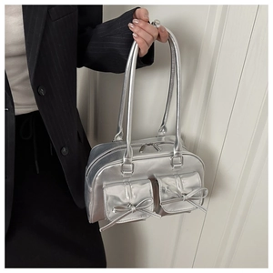 Detail of silver metallic PU shoulder bag featuring front pockets and bow accents