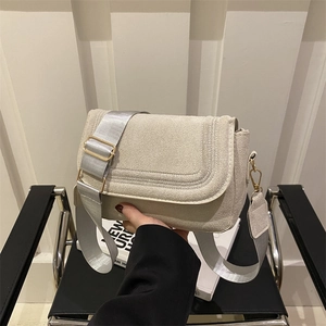 Modern apricot saddle bag with a minimalist flap design and a wide nylon shoulder strap