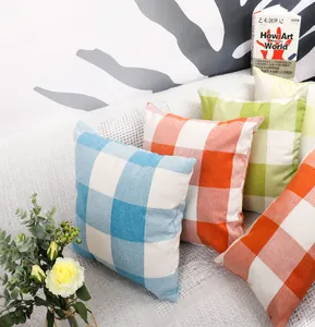Détail de housses de coussin à carreaux en plusieurs couleurs sur un lit douillet