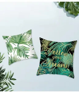 Detail of peach skin fabric cushion cover with tropical green leaves and printed quote