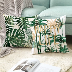 Nordic tropical green leaves cushion covers with Happy Life text on a blue sofa