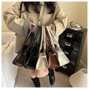 Detail view of stylish trapezoid underarm bags in brown, black, beige and camel colors