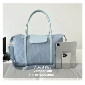 Detailed size comparison of light blue nylon travel bag with a tablet and phone