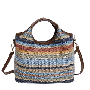 Colorful woven straw bucket bag with brown leather handles and a long shoulder strap
