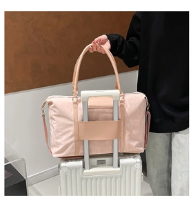 Pink travel bag with trolley sleeve attached to a white suitcase handle for easy carrying