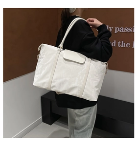 Detail of white large capacity travel tote bag with pleated texture and adjustable strap