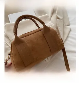 Detailansicht der braunen Wildleder Boston Tasche mit goldenen Metallbeschlägen