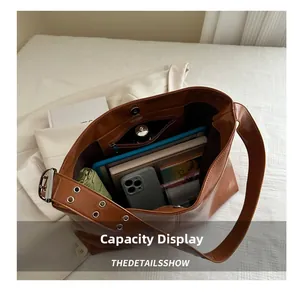 Dettaglio della capienza di una grande borsa tote in pelle PU marrone con tablet e oggetti