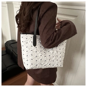 Détail du sac cabas blanc plissé avec motifs nœuds noirs et fine bandoulière