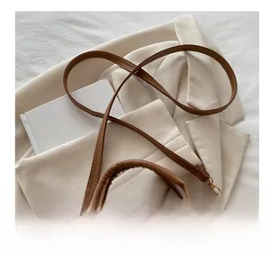 Nahaufnahme der braunen Wildledertasche mit schmalem Lederriemen und goldenem Reißverschluss