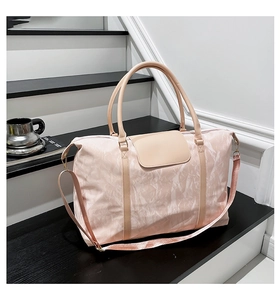 Detail of pink travel bag with marble texture on minimalist black and white steps