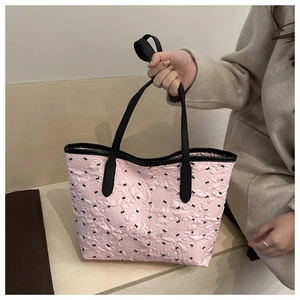 Détail du sac cabas rose à pois avec texture plissée et petits nœuds noirs décoratifs