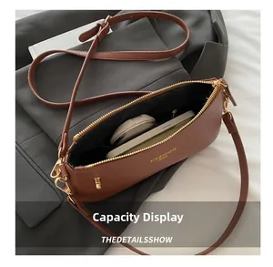 Detail view of brown pebbled leather crossbody bag showing phone and cushion storage