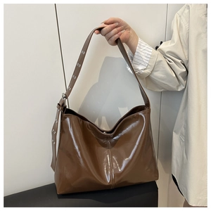 Dettaglio borsa Hobo in vernice marrone lucida con tracolla regolabile con occhielli