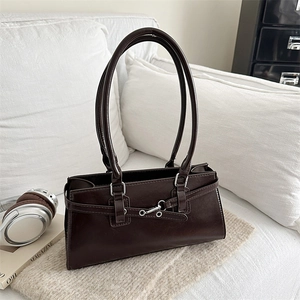 Retro deep brown faux leather shoulder bag with silver buckle in a cozy home setting