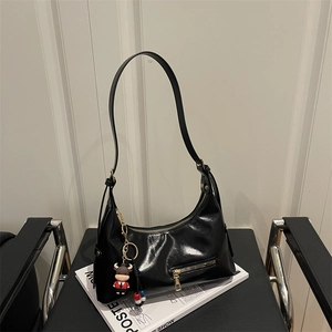 Glossy black hobo tote bag for women with decorative front zipper and cute cow charm