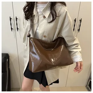 Dettaglio di una grande borsa tote in pelle verniciata marrone con fibbia in metallo argento