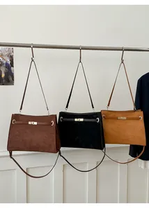 Trois sacs cabas en daim minimalistes en marron, noir et jaune avec détails de fermoir