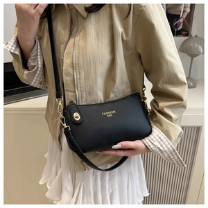 Chic black crossbody bag with litchi texture shown on a shoulder in a home setting