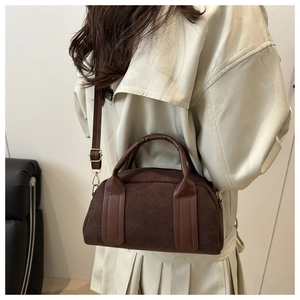 Detailansicht einer dunkelbraunen Wildledertasche kombiniert mit beigem Trenchcoat