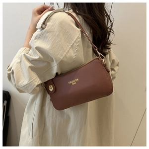 Detail of brown litchi pattern leather shoulder bag with gold zipper and metal hardware