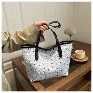 Détail du sac cabas blanc avec motif nœuds noirs et texture plissée gaufrée chic