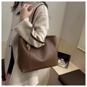 Detail of dark brown tote bag featuring Fashion & Bag embossing and silk scarf accessory