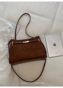 Détails d'un sac cabas vintage en daim marron avec fermoir tournant doré et bandoulière