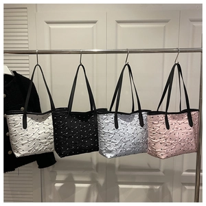 Détail de quatre sacs fourre-tout colorés avec motifs nœuds 3D et fines anses noires