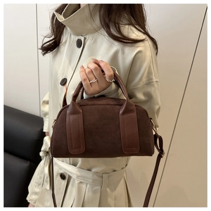 Braune Vintage Wildledertasche kombiniert mit einem beigen Mantel für einen modischen Look