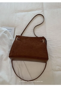 Détail du sac cabas rétro en daim marron montrant la boucle et le cuir lisse